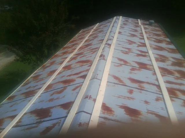 Rusted metal roof panels with new wood purlins before replacement — Storm Damage Roof Repair in Fabius by Roofing Brothers