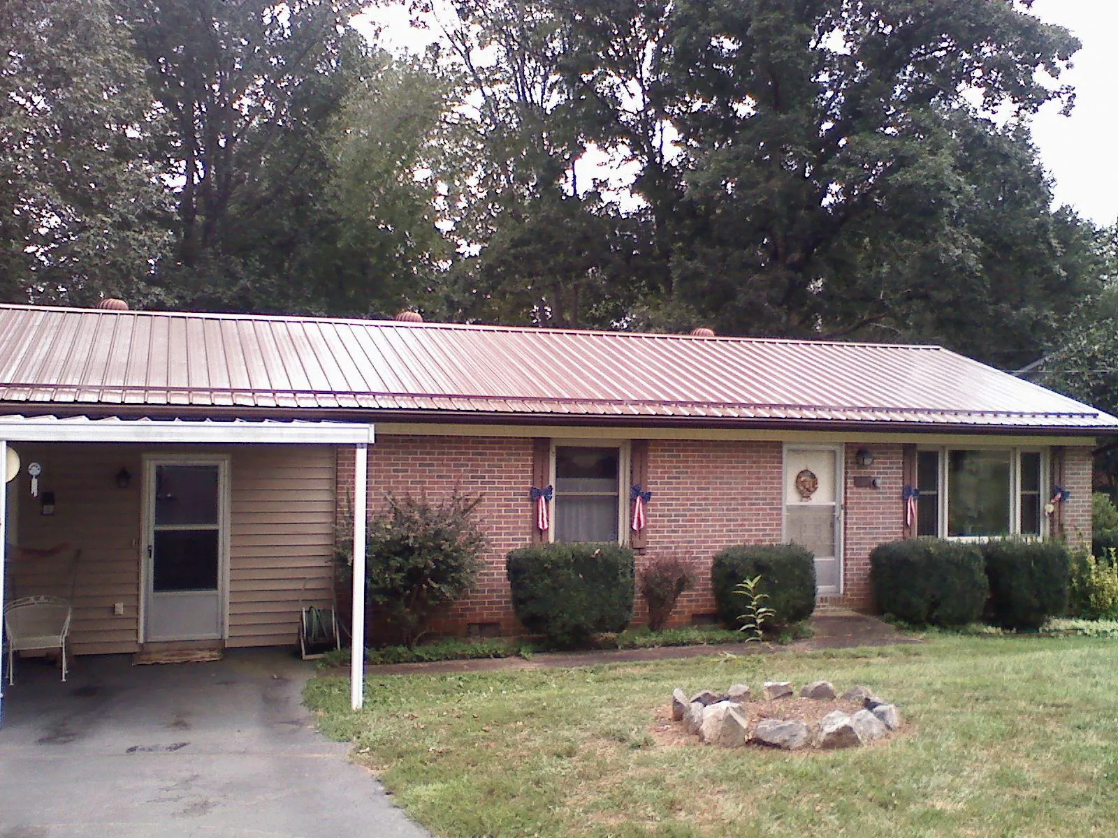 Bronze metal roof and carport on a brick ranch home — Roof Repair work by our crew in Fabius