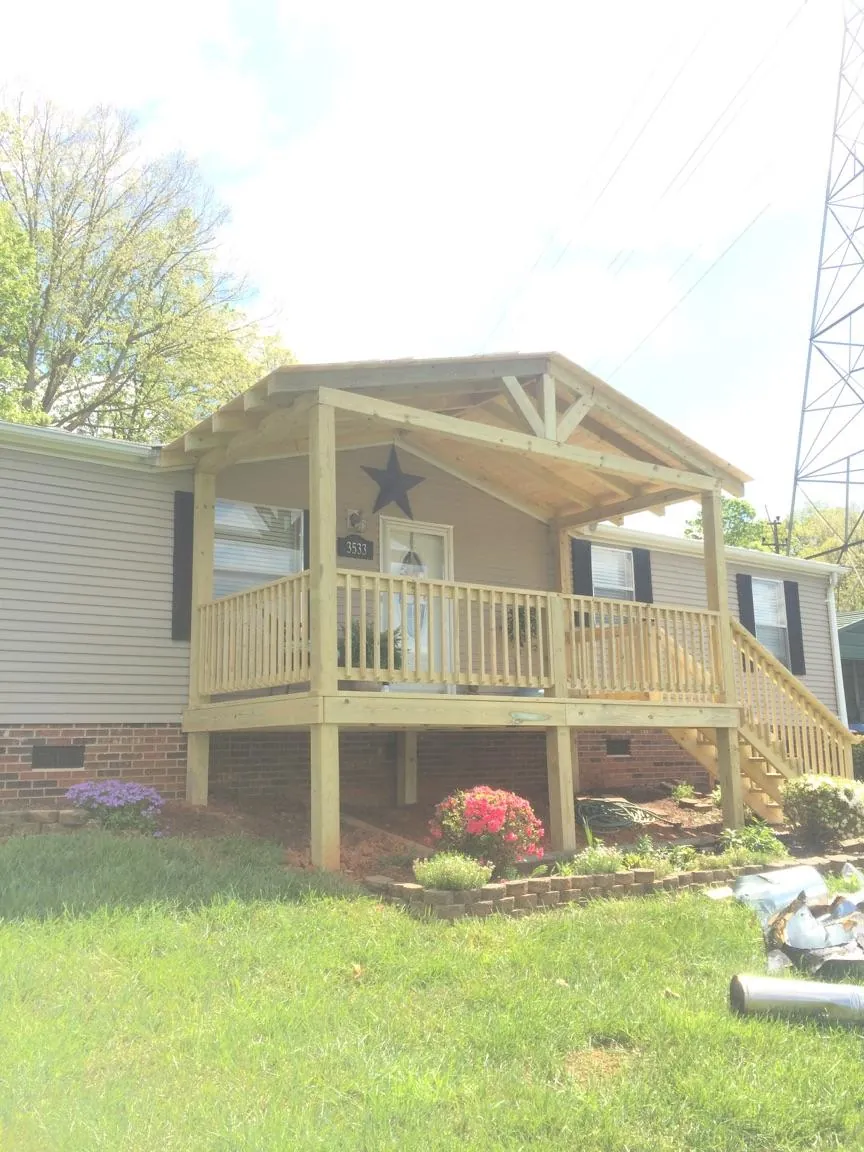 New gabled porch roof and deck railing added to a ranch home in Fabius
